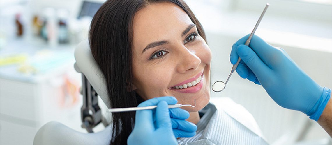 Woman smiling while doctor is getting ready to operate.